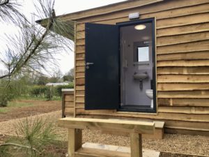 Bear Loo with door open showing mirror, sink and external wood cladding