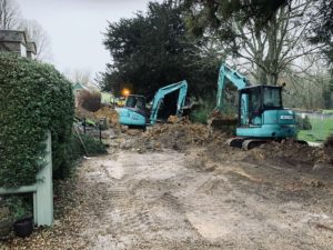 Two diggers working in a tight space